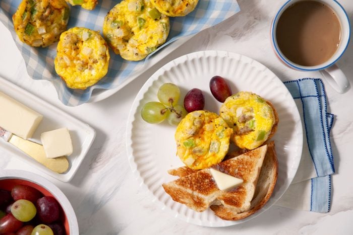 Egg Muffins served in a plate with bread toast tea and fruits 