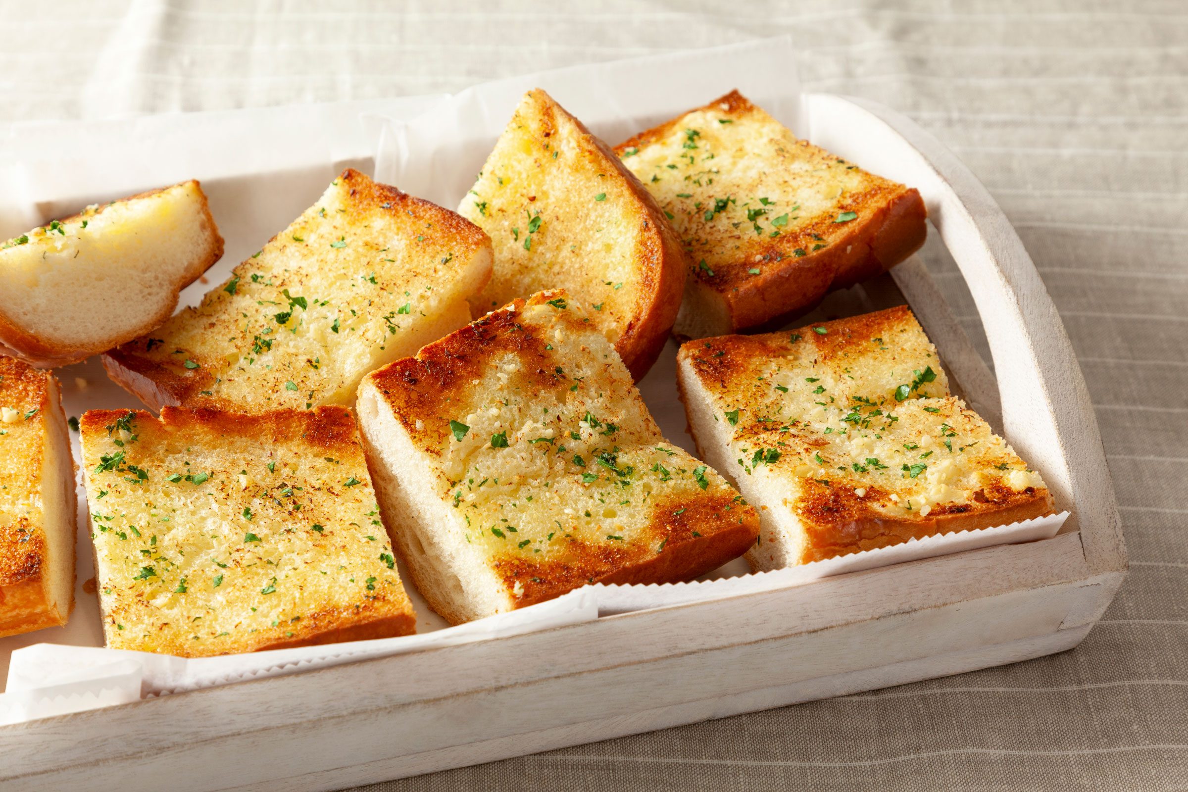 close up of garlic bread slices in a white baking dish