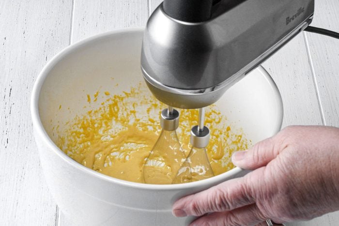 Beating egg yolks in a large bowl with whipping machine