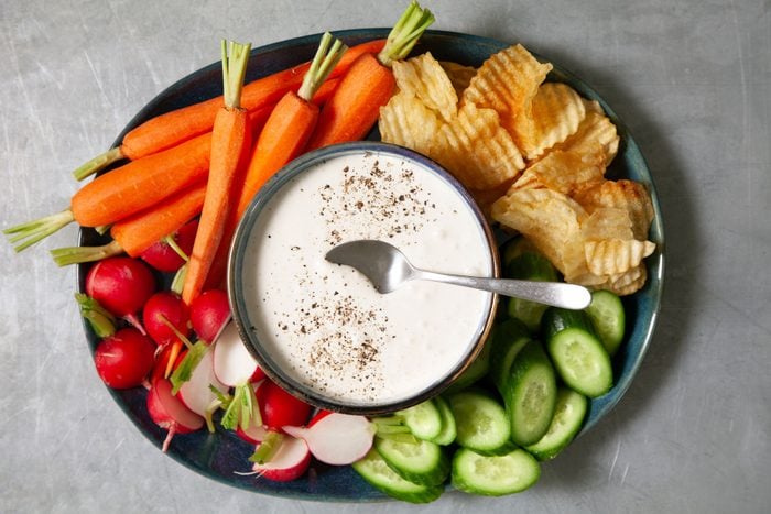 Garlic Dip served in a bowl with vegetables and snacks on side