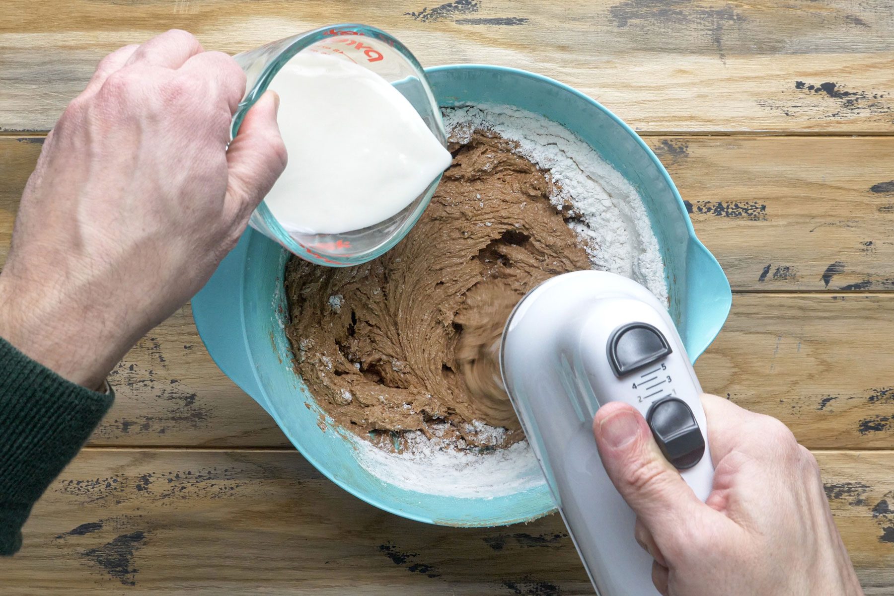 Pouring buttermilk in the chocolate batter in a large bowl