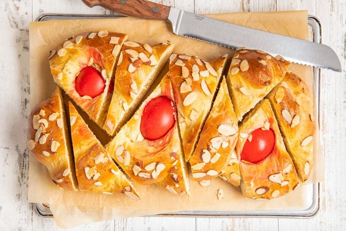 Greek Easter Bread on a Baking Sheet on Baking Tray with Knife on White Painted Wooden Surface