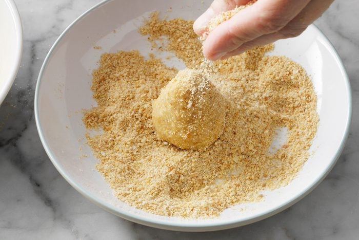 Covering egg water mixture covered ham balls again in bread crumbs