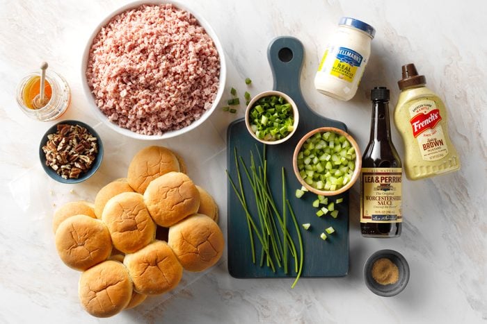 Ham buns mayonnaise green onions and other ingredients on a marble countertop