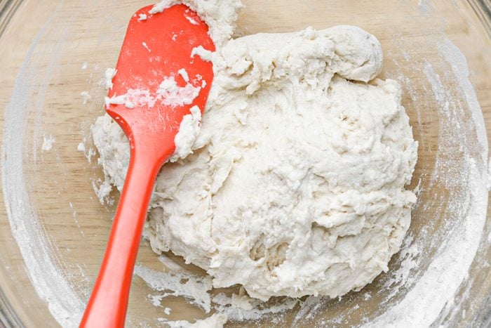 spatula and dough in a large glass bowl