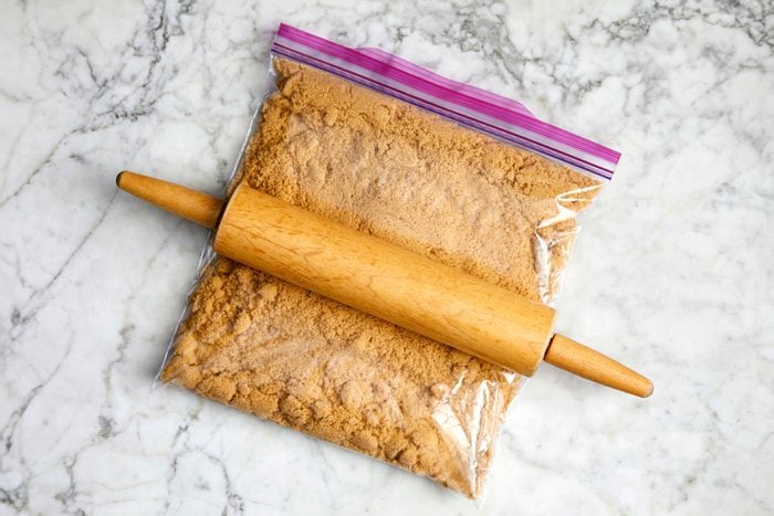 rolling pin on a ziploc bag of brown sugar on a marble kitchen counter