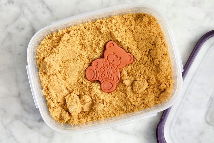 Terracotta bear in a container of brown sugar