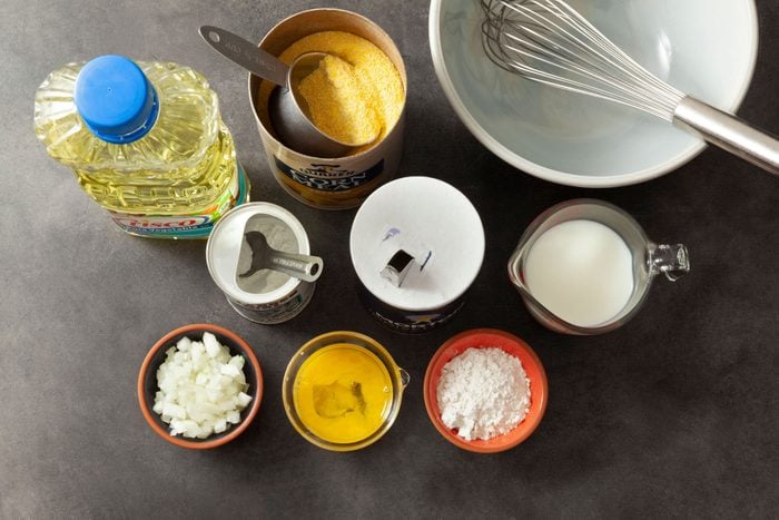 Cornmeal Flour Baking powder and other ingredients placed on a grey surface.