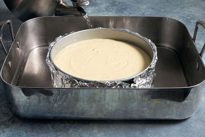 Adding water in large baking pan 