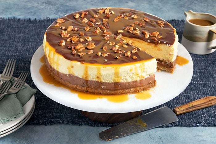Layered Turtle Cheesecake served on cake serving plate