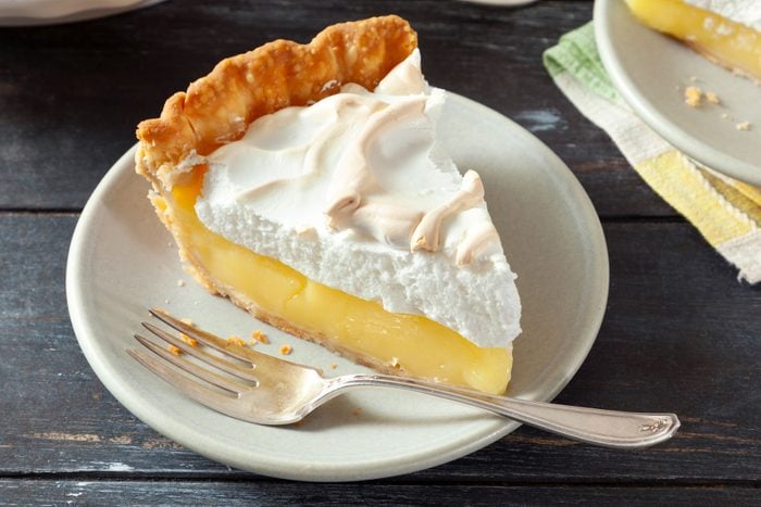 A slice of Lemon Meringue in a plate with fork