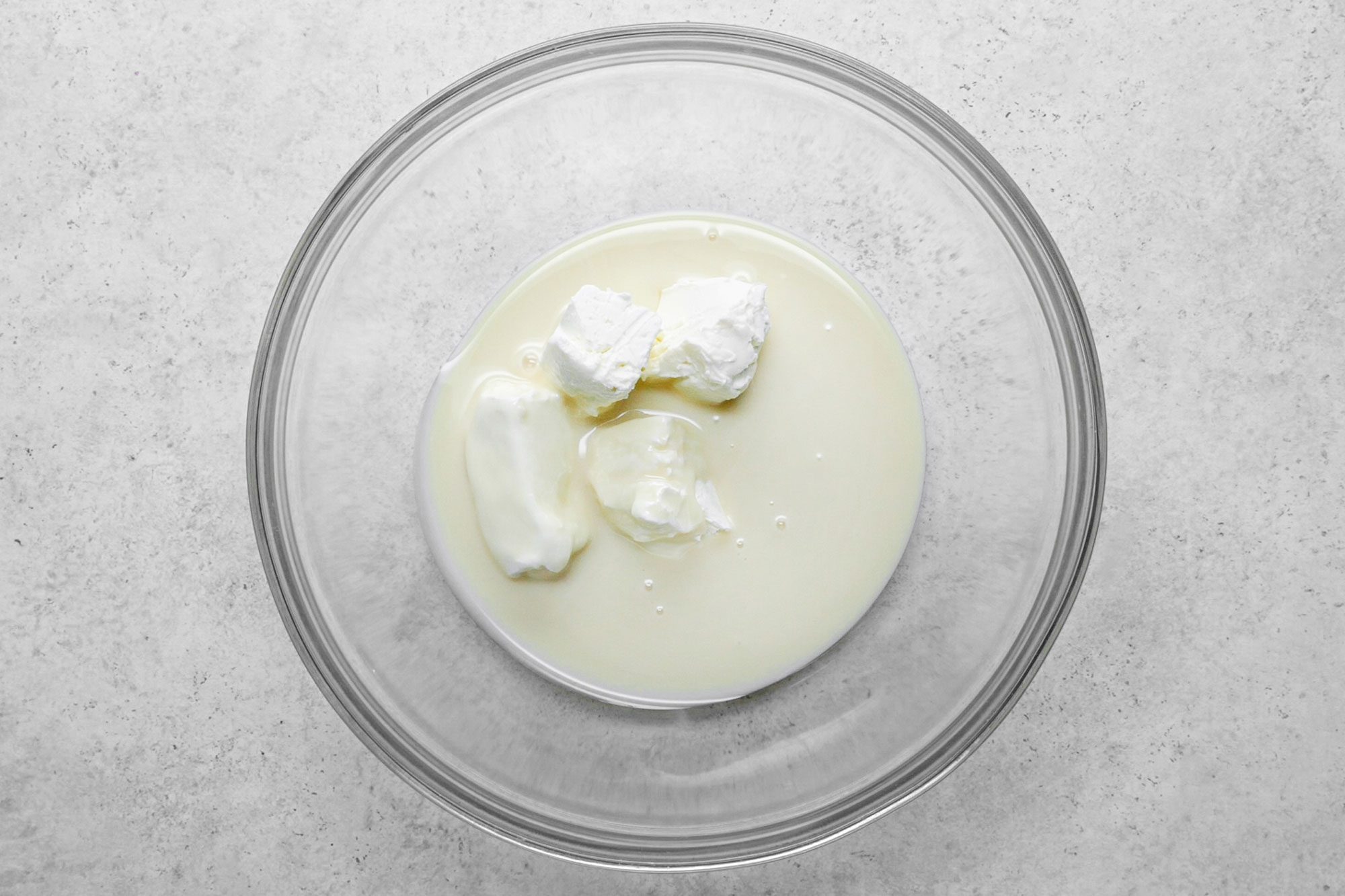 cream cheese and milk in a large glass bowl
