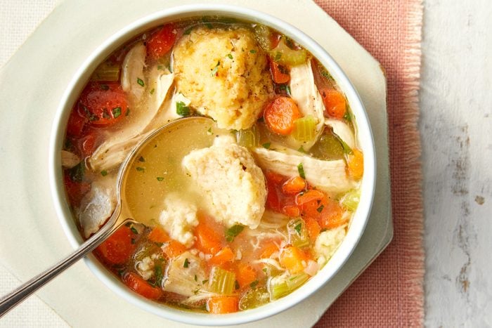 A bowl of matzo ball soup with a spoon