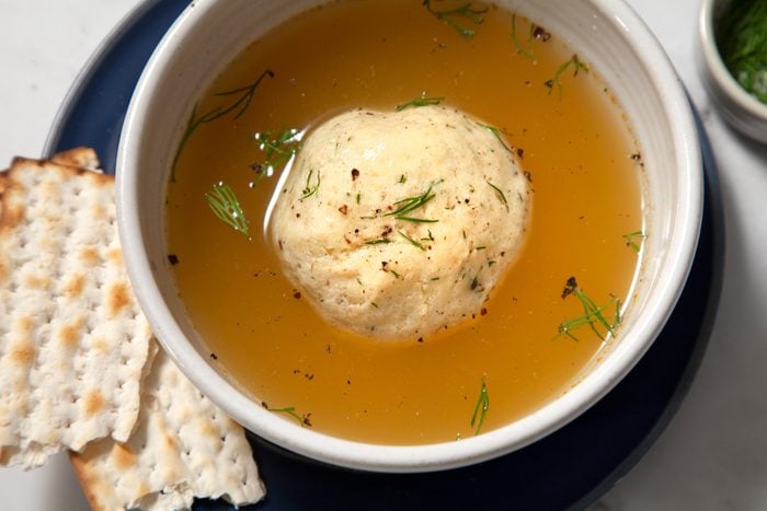 A bowl of chicken soup with matzo ball