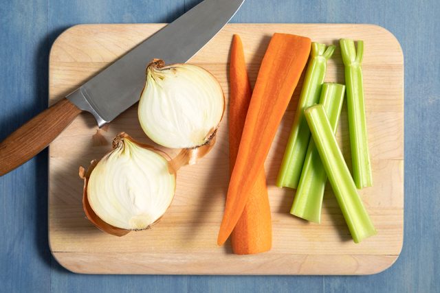 Mirepoix ingredients on wooden cutting board with knife