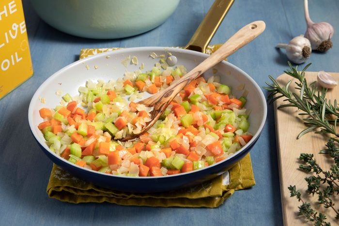 Mirepoix ready to serve in frying pan with wooden spatula