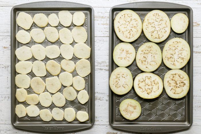 Arrange the potato slices on one, and the eggplant slices on the other in two greased baking sheets