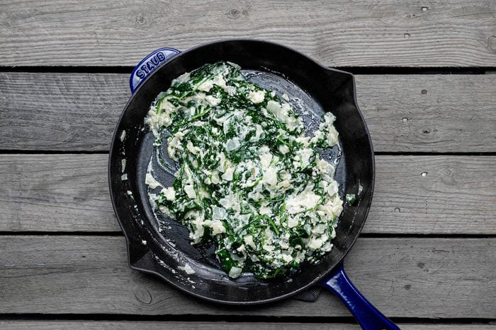 Cooked onion and spinach in skillet