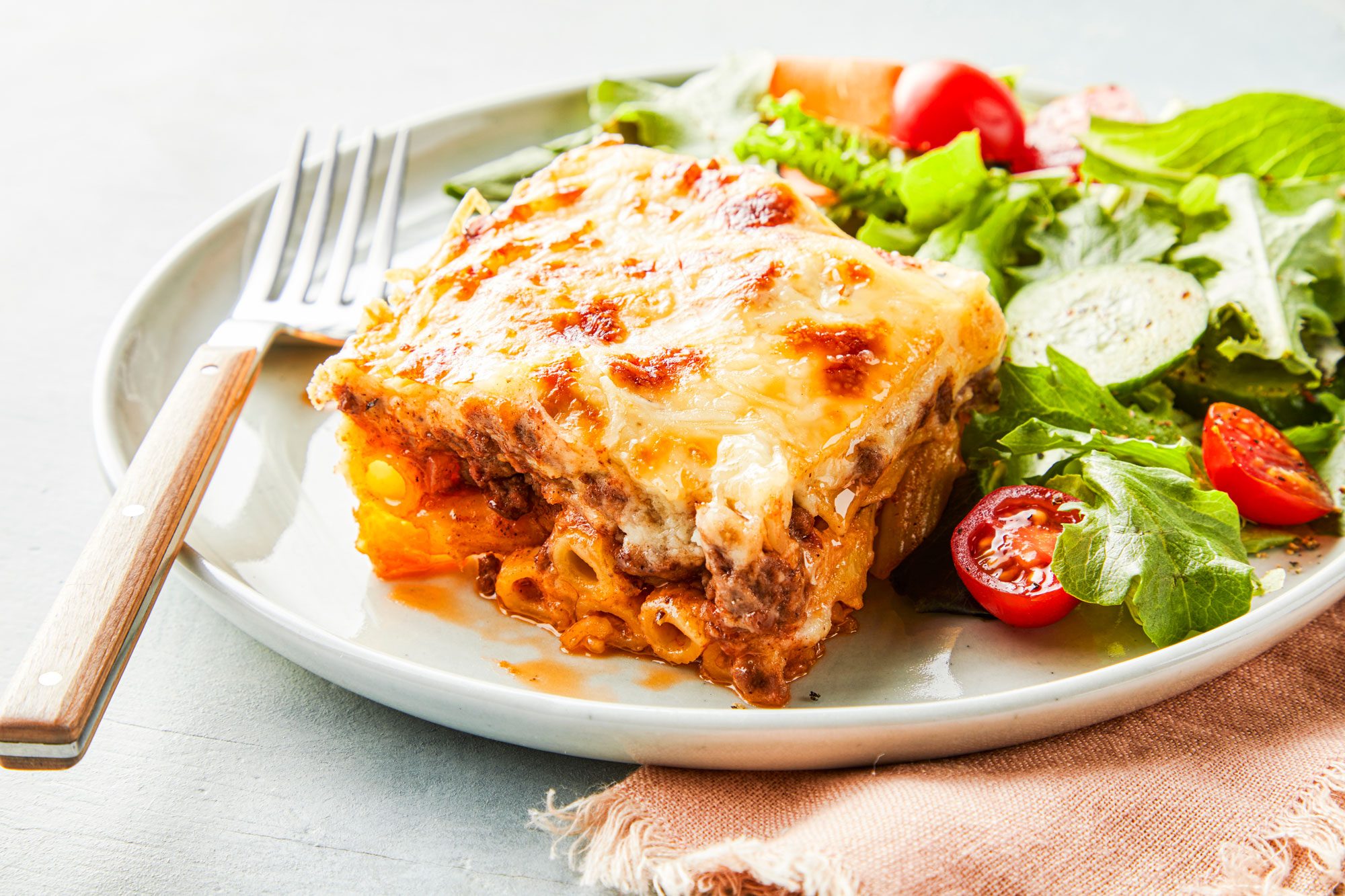 Pastitsio with fresh veggies in a plate