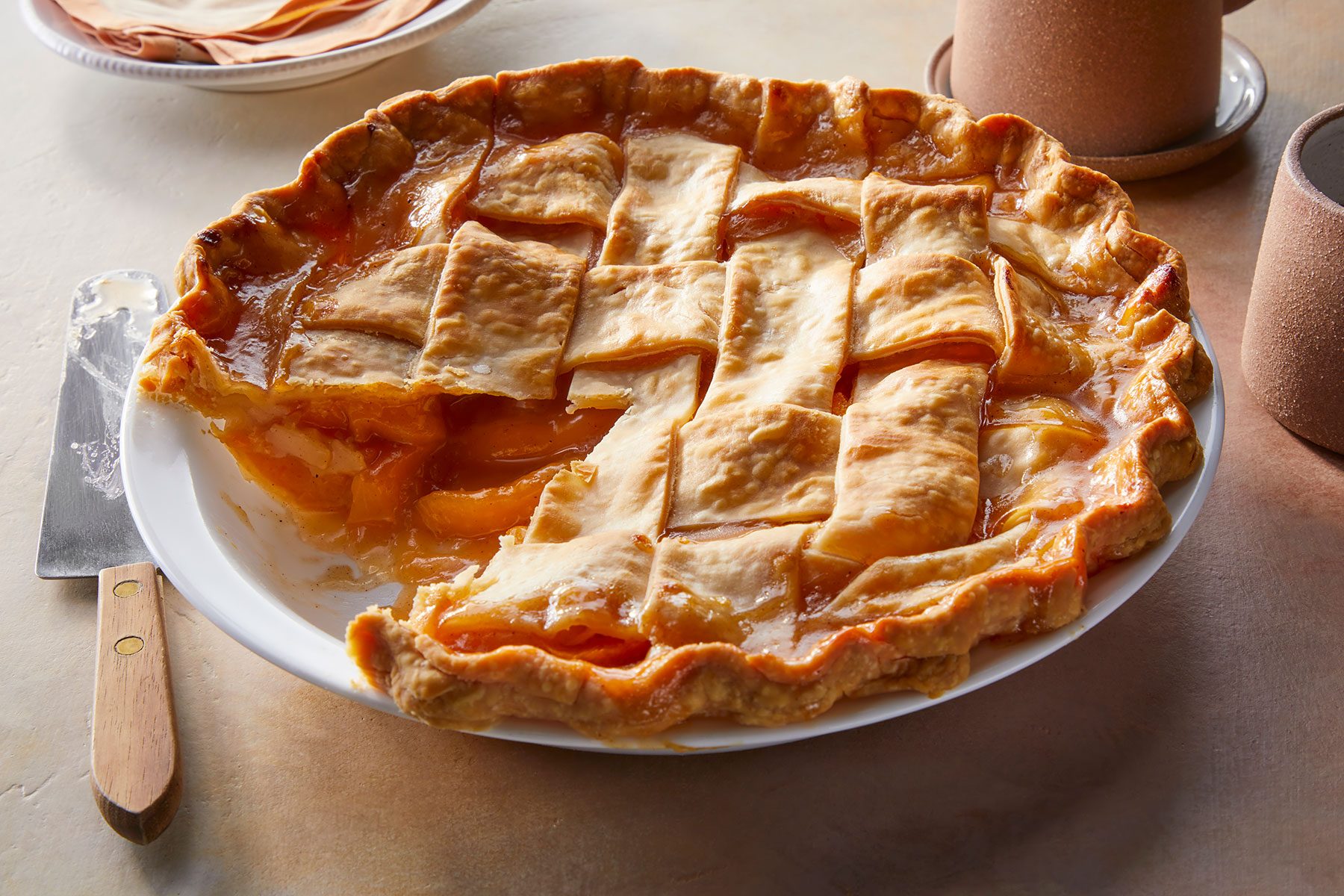 Slice of Peach Pie cut out of whole peach pie