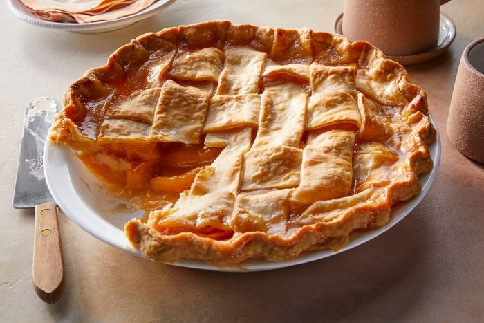 Slice of Peach Pie cut out of whole peach pie
