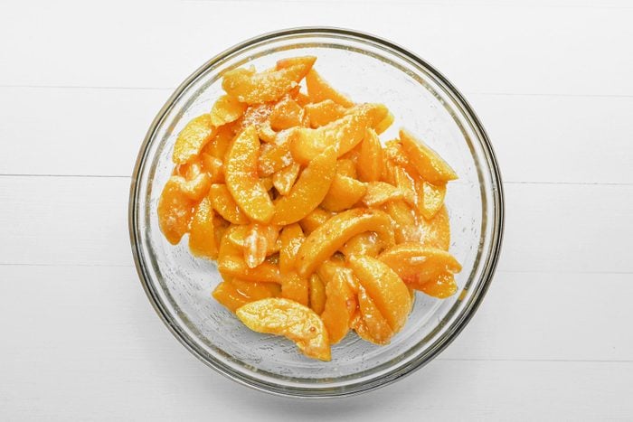 Pieces of Peach in a bowl covered with sugar