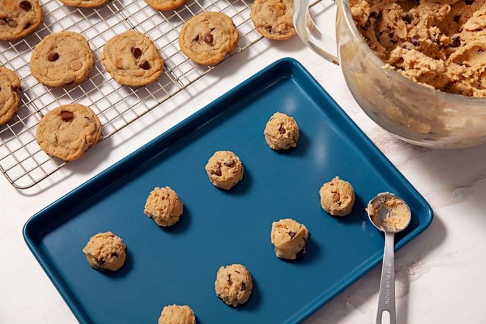 Cookie dough dropped onto a blue tray