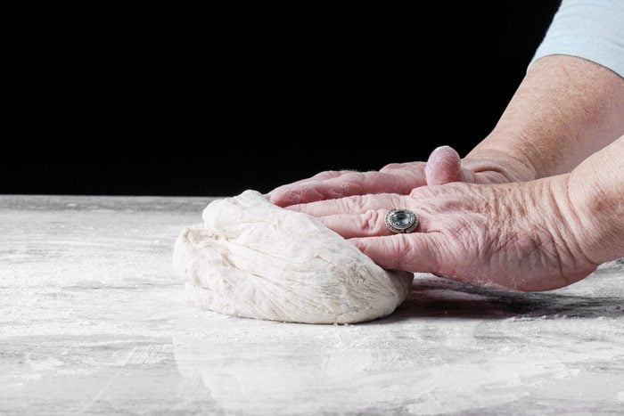 Knead the with hands dough on a floured surface 