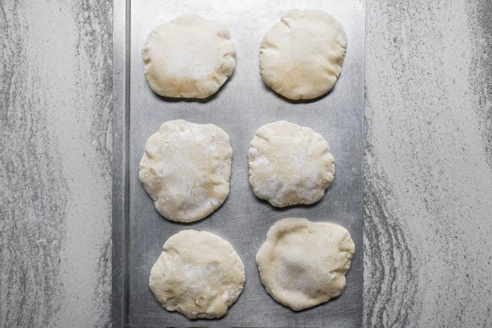 Six pieces of small dough on a baking tray