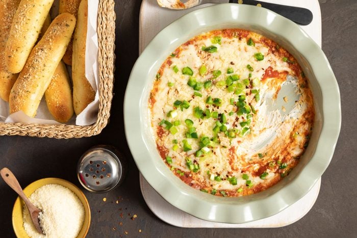 Pizza Dip in a large plate served with bread on a countertop