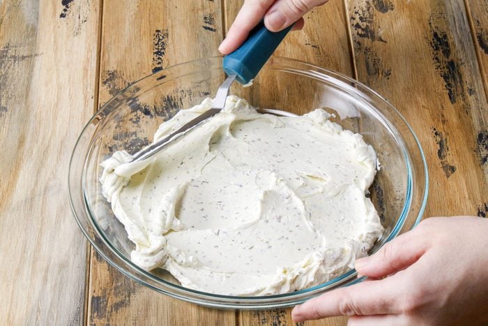 Spreading cream cheese in a large bowl
