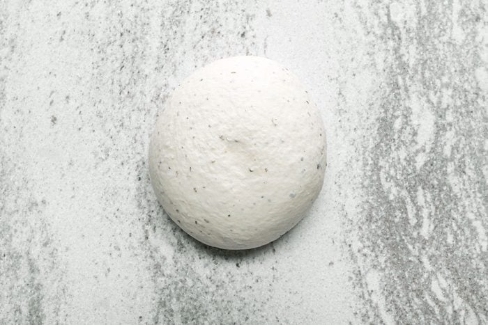 Pizza Dough ball resting white surface