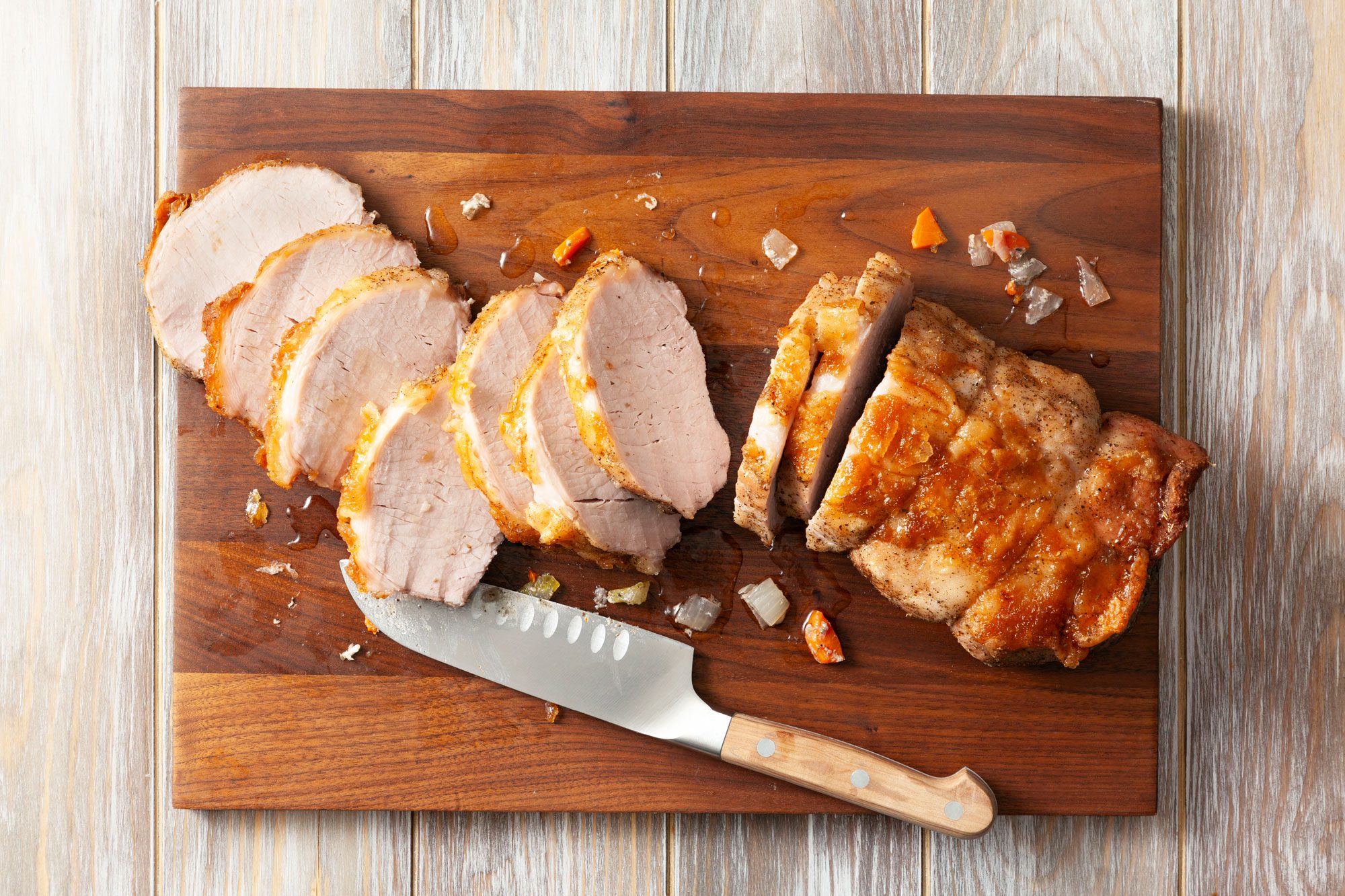 Sliced pork roast on cutting board with knife