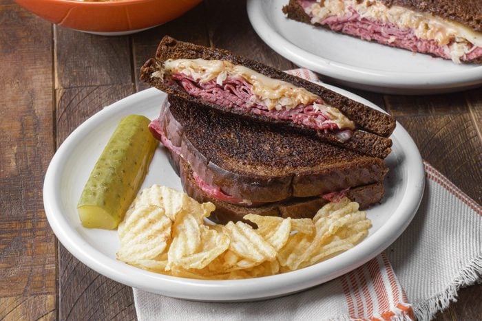 Reuben Sandwiches served on a plate with chips
