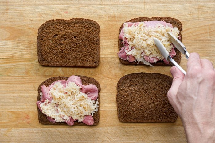 Layer each sandwich with a sauerkraut and beef on a wooden surface