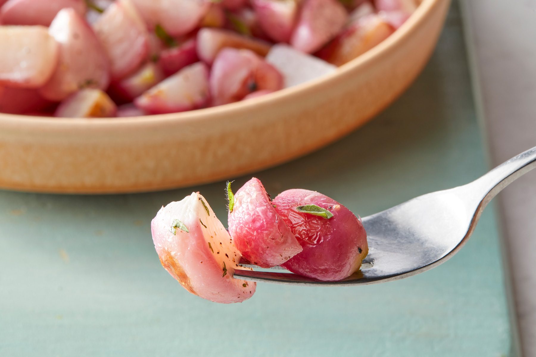 A fork with pieces of roasted radishes on it