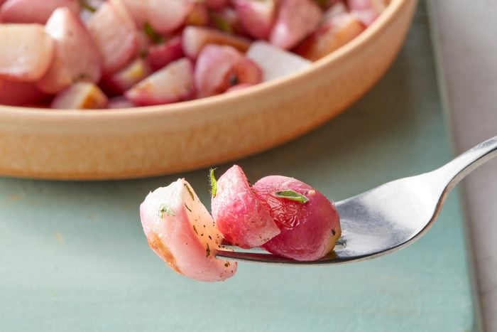 A fork with pieces of roasted radishes on it
