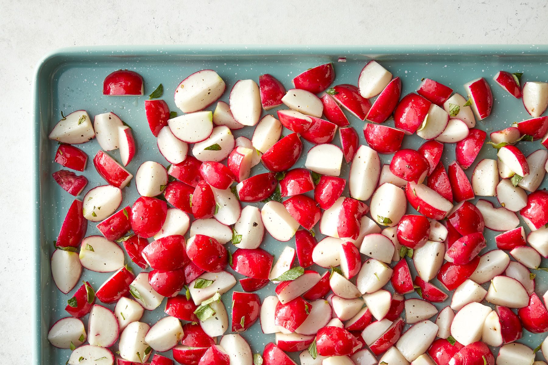 A tray of radishes on a white surface