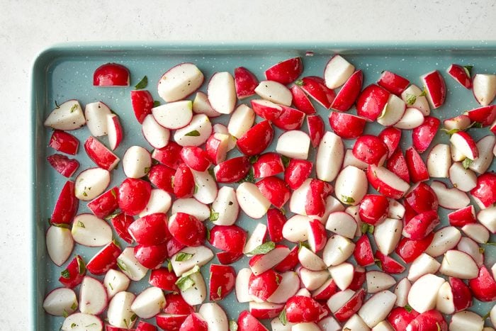 A tray of radishes on a white surface