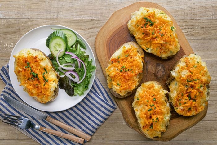 Shepherds Pie Twice Baked Potatoes served in a plate with vegetables on a wooden surface