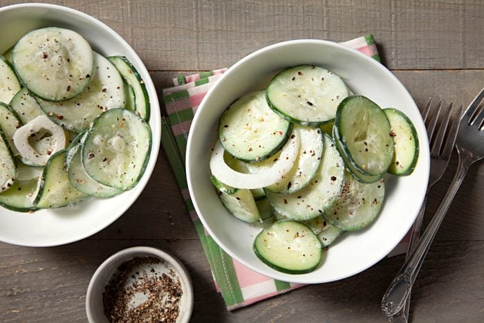 Sour cream cucumbers in a bowl on a table