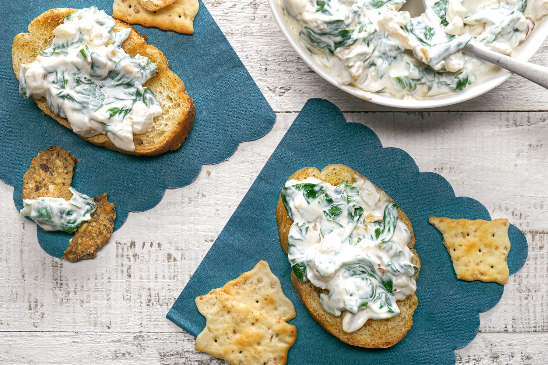 Spinach dip served with crusty breads, crackers and tortilla chips. 