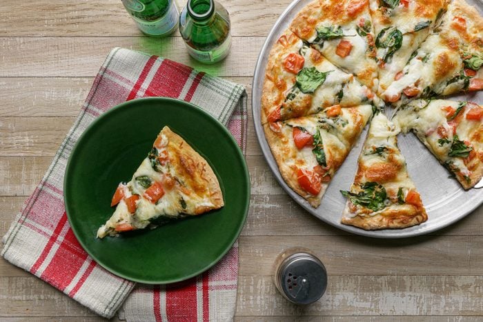 Spinach Pizza slices served on plate with beverage