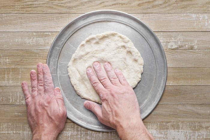 Prepare the dough for pizza crust on a wooden table