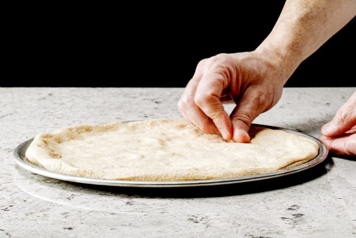 rolling our dough into a pizza shape