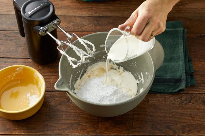 pouring milk into a bowl to make frosting