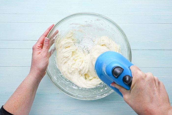 making frosting in a glass bowl with mixers