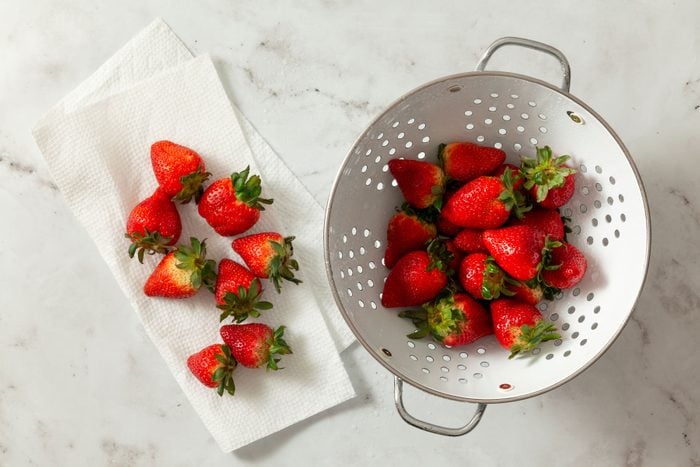 Fresh strawberries in a placed on a napkin on a marble surface