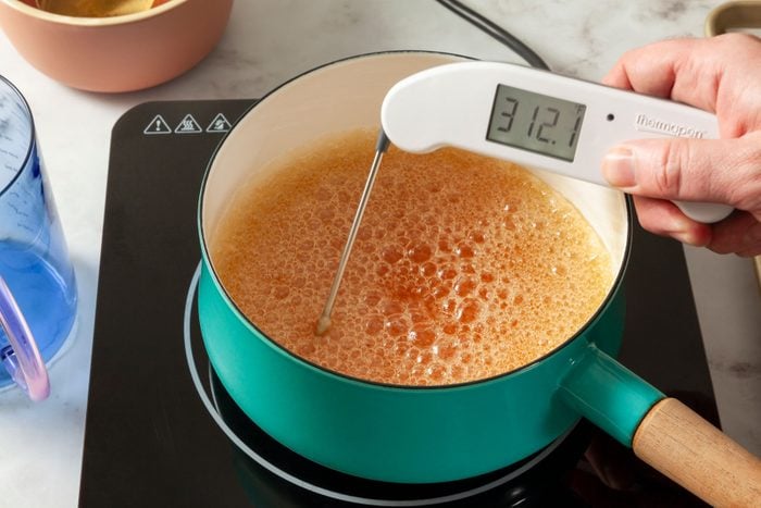 Boiling the sugar mixture in a large saucepan and using candy thermometer to read temperature