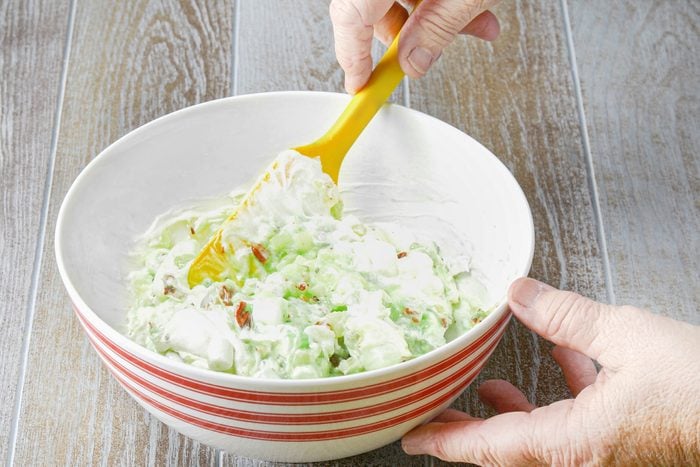 Stirring the salad mix with whipped topping